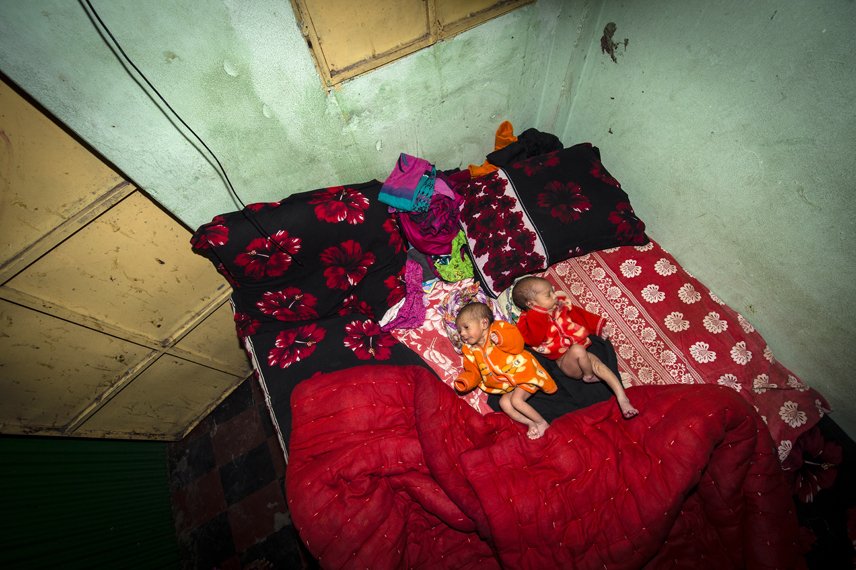 Five days old twins lie on the bed. They have not yet a name. Jhinik, 20 years, a sexworker in the Kandapara brothel gave birth to them.