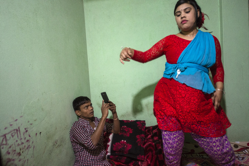 Rupa, 16, is dancing on the bed while a customer is filming her in the Kandapara brothel in Tangail.