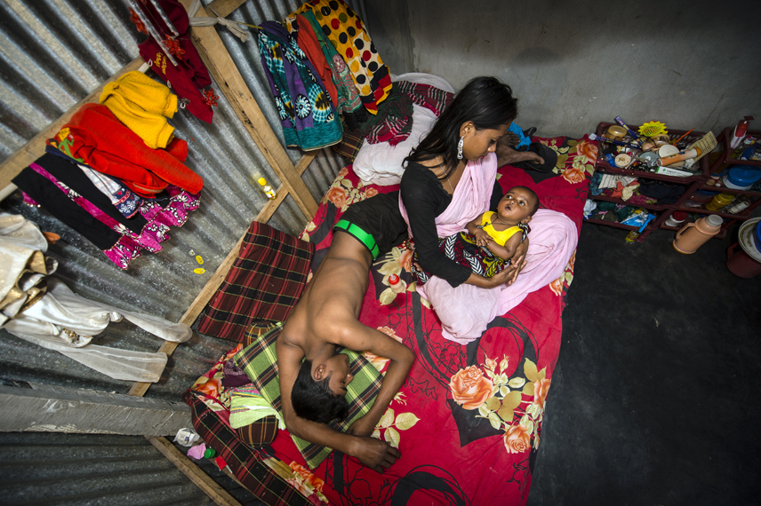 Kajol with her 6 month old baby Mehedi and a customer on her bed. She thinks she is 17 years but does not know her exact age. She was married with 9 years. Her aunt sold her to the Kandapara brothel. Two weeks after the birth she was forced to have sex again with customers. Because of the baby her business is not so good.