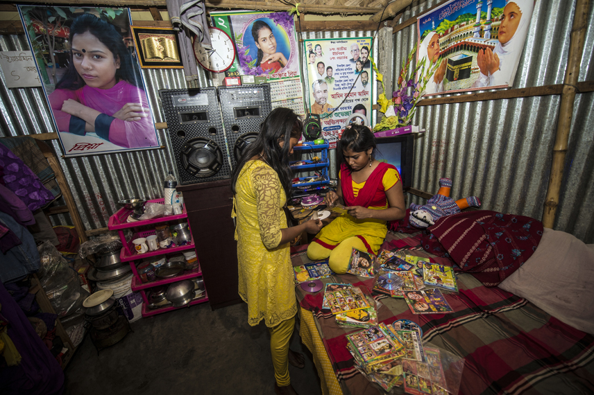 Priya, 19, on the bed, and Kajol, 17, are looking for music in Priya«s room. Both are working as sex workers in the Kamdapara brothel in Tangail.