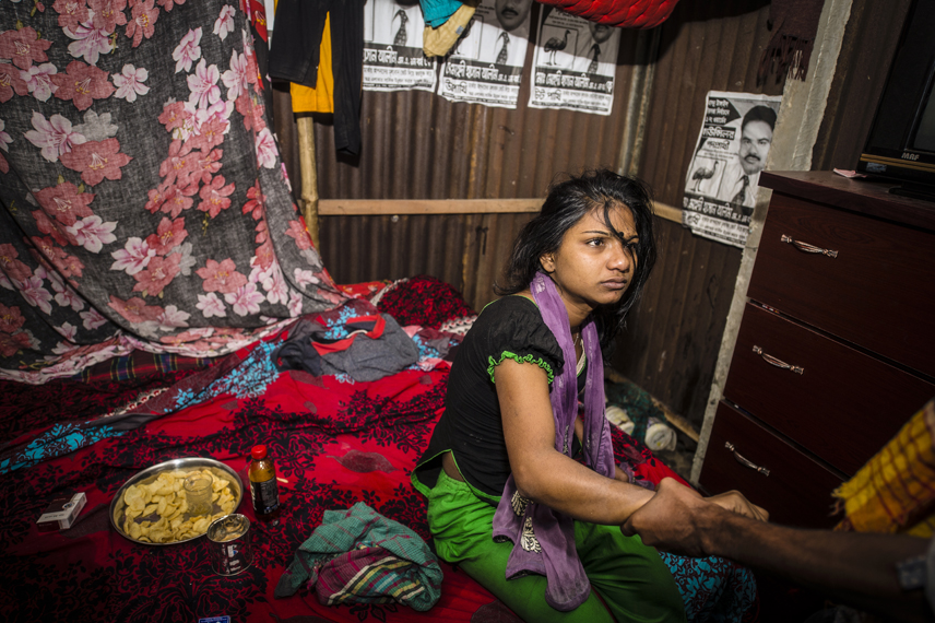 Sumaiya, 17, in the Kandapara brothel in Tangail. Her boyfriend and regular customer Titu, 23, pulls her on her arm. He is from Dhaka and visits ger every month one week. They are often fighting, because Titu wants to marry her, but she doesn«t want. She is afraid that after marriage he will take away all her money. He is jealous, because she has sex with many of his friends. Sumaiya is jealous because he has sex with other sexworkers in the brothel.